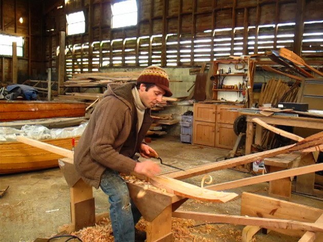 A boat builder making a boat.